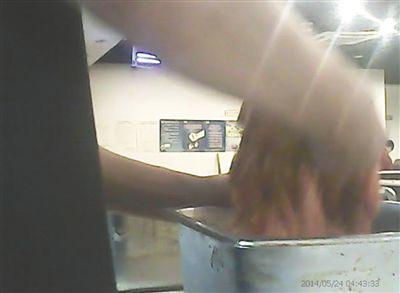 在開餐前，烤肉店一名員工正徒手攪拌肉片。
